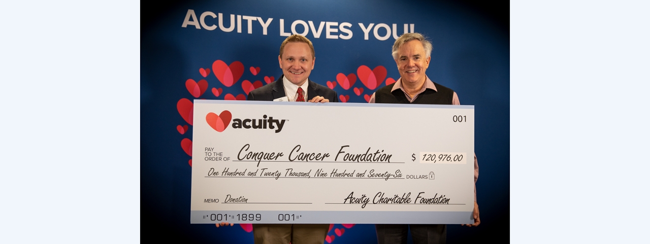 Conquer Cancer Foundation: Acuity President and CEO Ben Salzmann (right) presents a check to Dave Wiemer, Philanthropic Officer at Conquer Cancer Foundation. Conquer Cancer Foundation received over $120,000 from Acuity, while five other charities received a total of nearly $380,000.