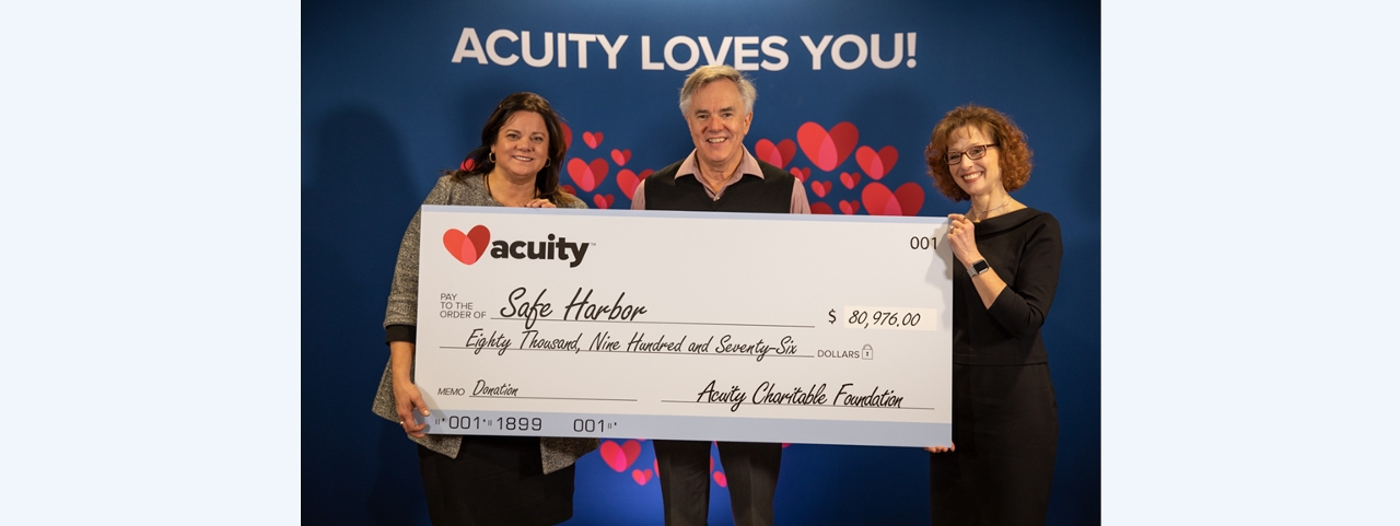 Safe Harbor: Safe Harbor Executive Director Laura Roenitz (left) accepts a check for nearly $81,000 from Acuity President and CEO Ben Salzmann and Sheri Murphy, Vice President - Services and Administration.
