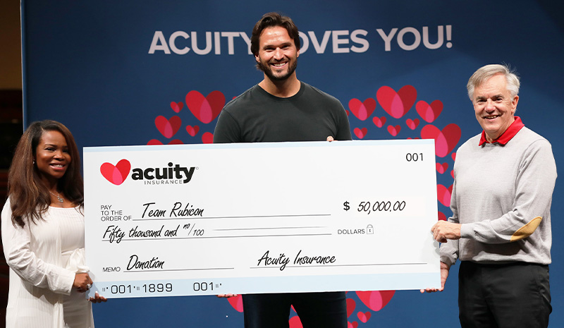 Jake Wood (center), Executive Chairman of Team Rubicon, receives a $50,000 donation from Acuity presented by Danni Norlander (left), Manager - Premium Audit, and Ben Salzmann (right), President and CEO. As the fastest growing disaster response organization, Team Rubicon’s over 150,000 volunteers, comprised primarily of military veterans, have responded to nearly 1,000 disasters in the U.S. and around the world.  By pairing the skills and experiences of military veterans with first responders, medical professionals, and technology solutions, Team Rubicon aims to provide the greatest service and impact possible.