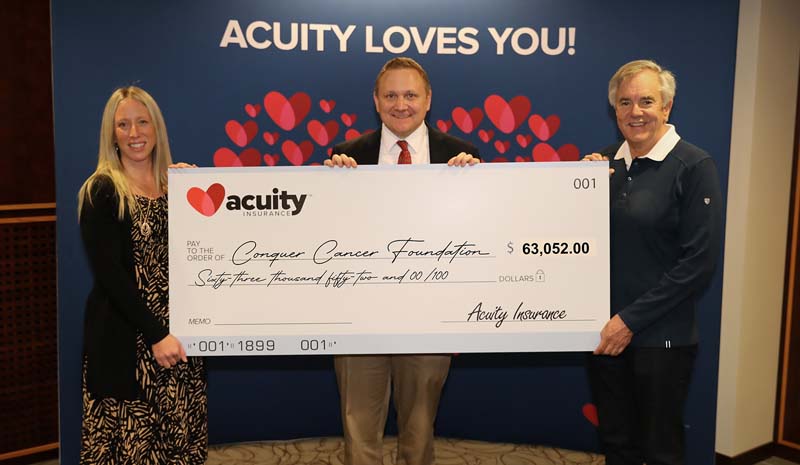 Dave Wiemer from Conquer Cancer, the ASCO Foundation, accepts a check for over $63,000 from Acuity’s Alissa Burgos and Ben Salzmann.