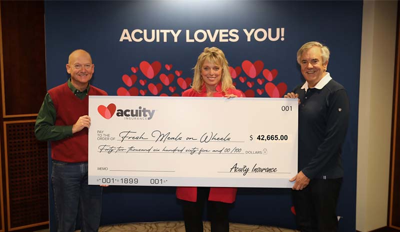 Kelly Anderson from Fresh Meals on Wheels accepts a check for nearly $43,000 from Acuity’s Wally Waldhart and Ben Salzmann.