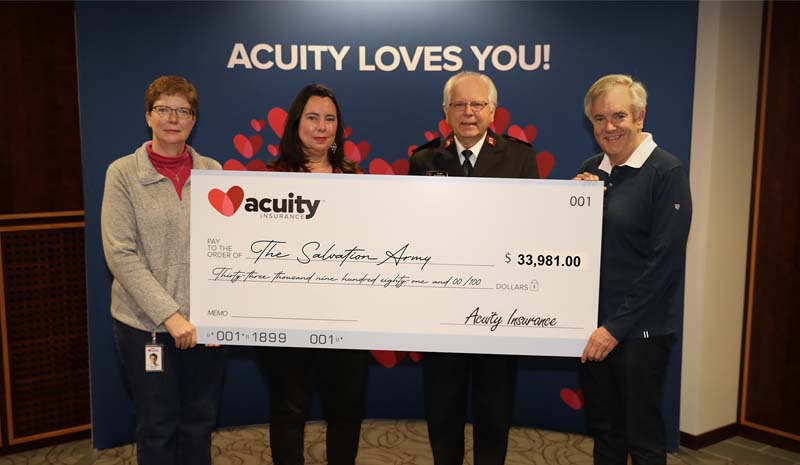 Carrye Jo Cony and Major Jay Davis of The Salvation Army accept a check for almost $34,000 from Acuity’s Wendy Schuler and Ben Salzmann.